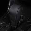 A close-up view of a black gear shift knob cover with a perforated texture, shown in a dark interior context.
