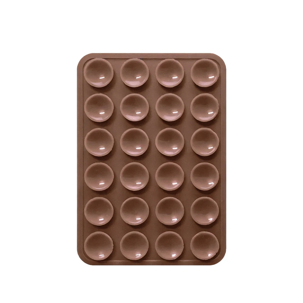 A brown silicone suction pad with multiple circular indentations for phone mounts.