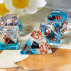 A set of colorful resin dice, including a triangular die and cubes, are displayed on a wooden surface with white flowers in t