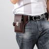 A brown leather waist bag with a silver buckle is worn on a dark denim jean belt.
