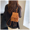 Petit sac à dos à cordon en cuir marron porté par une personne, vu de dos.