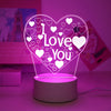 A glowing pink heart LED night light with a 'I Love You' design illuminating various small hearts.