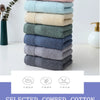 A stack of six textured cotton face towels in various shades of blue and green on a white surface.