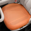 An orange breathable leather car seat cushion is shown placed in a white car seat interior.
