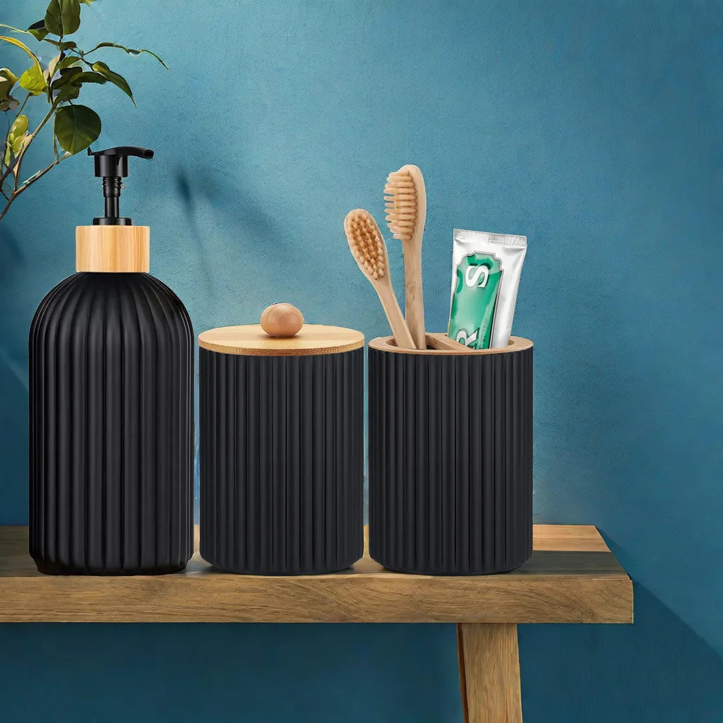 A black bathroom organizer set featuring a soap dispenser, cotton storage, and a toothbrush holder on a wooden shelf.