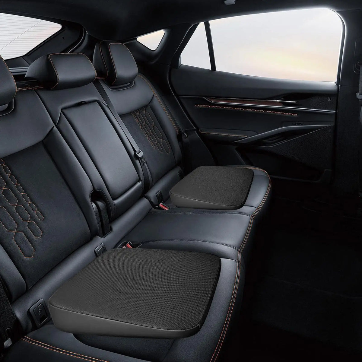 Vista interior de un asiento de coche con asientos de cuero negro y un cojín ergonómico en forma de cuña.