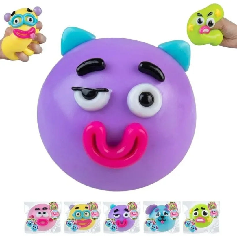 A purple squishy toy shaped like a face with large eyes and a pink tongue, shown next to similar toys.