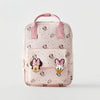 A pink backpack featuring a cute cow print pattern and Minnie Mouse designs.