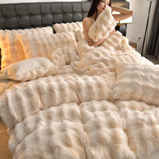 A woman is relaxing on a bed covered with fluffy cream-colored faux fur bedding.