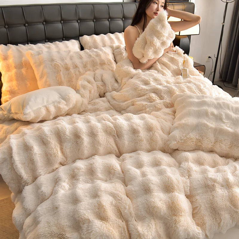 A woman is relaxing on a bed covered with fluffy cream-colored faux fur bedding.