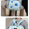 A light blue waterproof backpack diaper bag with blue floral patterns and black straps being held by a person.