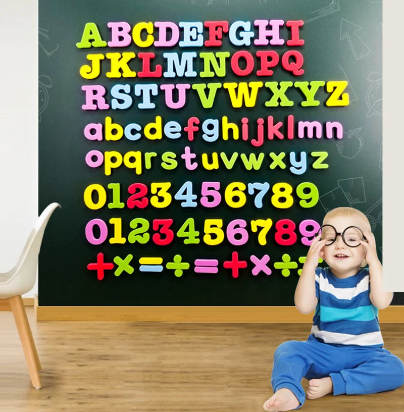A young child sits in front of a chalkboard covered with colorful magnetic alphabet letters and mathematical equations.