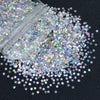 A close-up view of shiny holographic star sequins scattered across a dark surface.