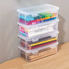 Clear plastic storage boxes with lids containing various colored pencils and pens.