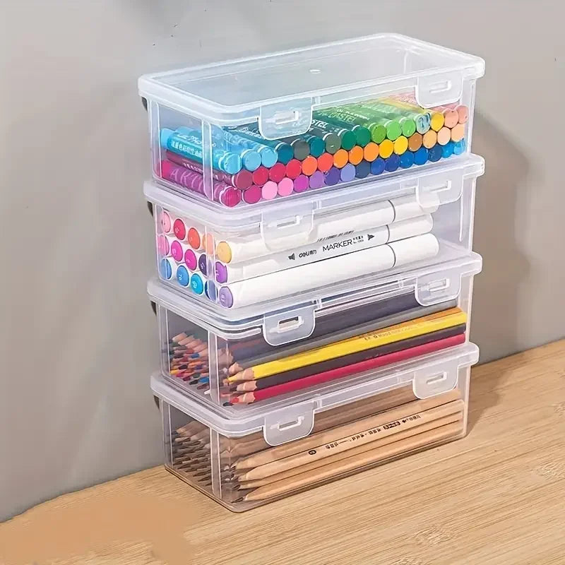 Clear plastic storage boxes with lids containing various colored pencils and pens.