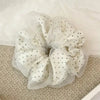White polka dot mesh scrunchie hair ties shown on a light surface.