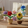 A set of creative flower pot building blocks featuring roses, sunflowers, and carnations in various colors.