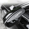 A matte black carbon fiber rain guard for a car's rearview mirror.