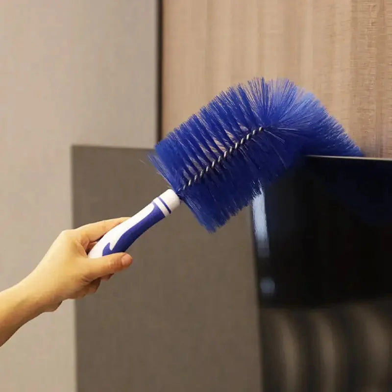 A hand holds a blue fan duster brush with a long handle, poised for cleaning.