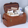 A brown leather toiletry bag with a flap open, showing various cosmetic and skincare products inside.