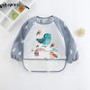 A baby feeding smock with a gray and white striped design featuring birds and clouds.