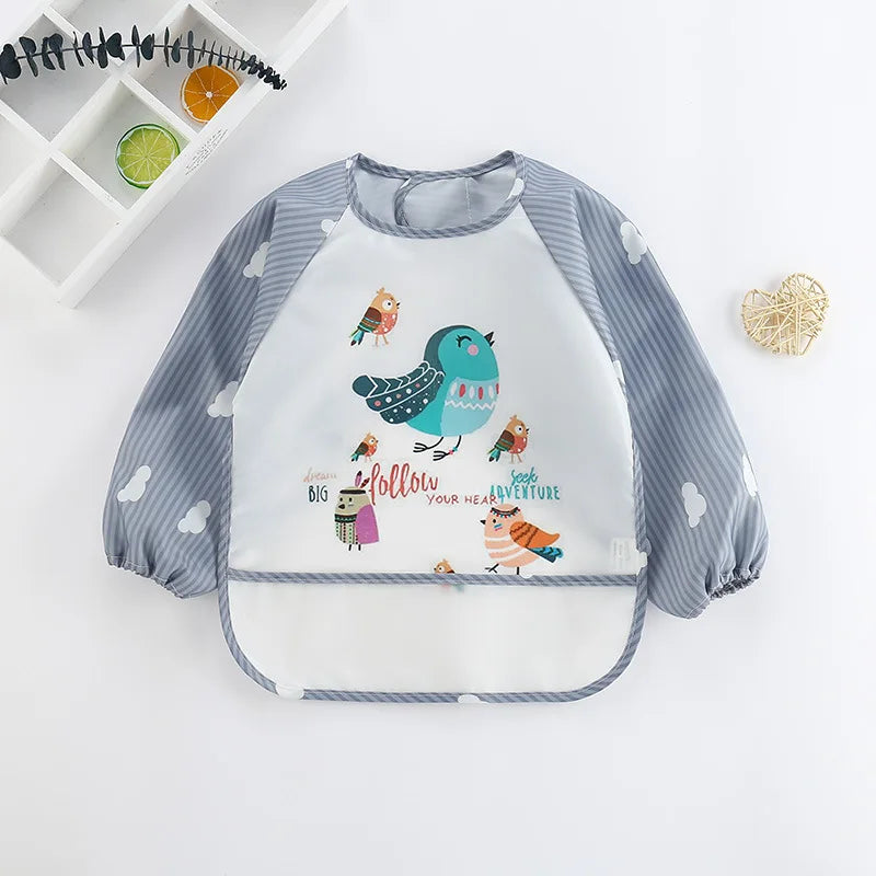 A baby feeding smock with a gray and white striped design featuring birds and clouds.