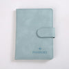 Porte-passeport en cuir bleu clair avec rabat cousu et le mot PASSPORT gravé.