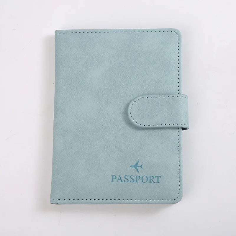 Porte-passeport en cuir bleu clair avec rabat cousu et le mot PASSPORT gravé.