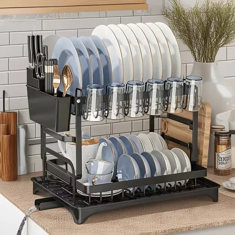 A black two-tier kitchen countertop drying rack holding stacks of white and blue plates and cups.
