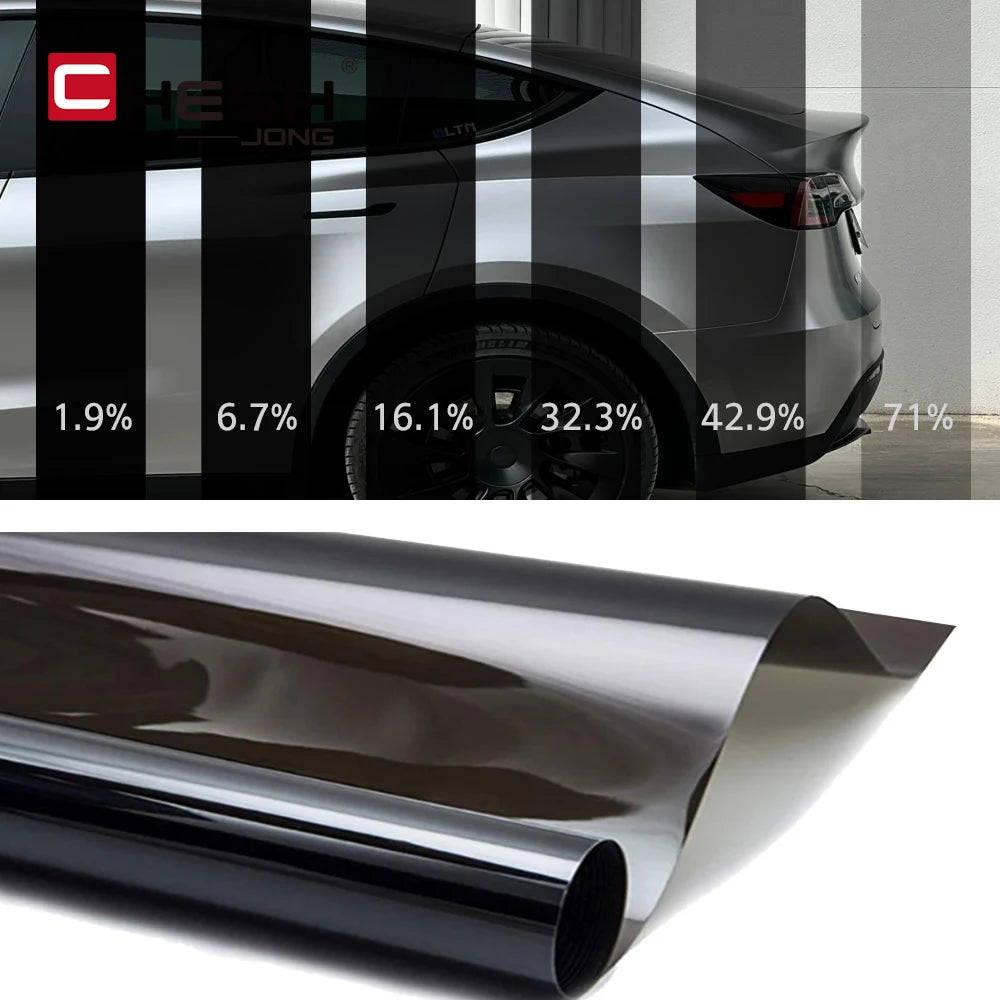 A roll of dark automotive window tint film being rolled out for application.