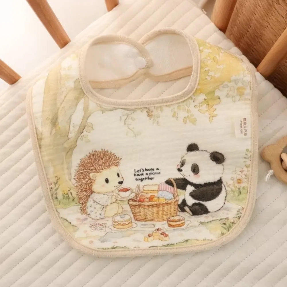 A soft cotton baby bib featuring cute panda and lion characters on a light yellow background.