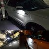 Close-up of a white Ford vehicle with an aftermarket LED puddle light installed on the side mirror.