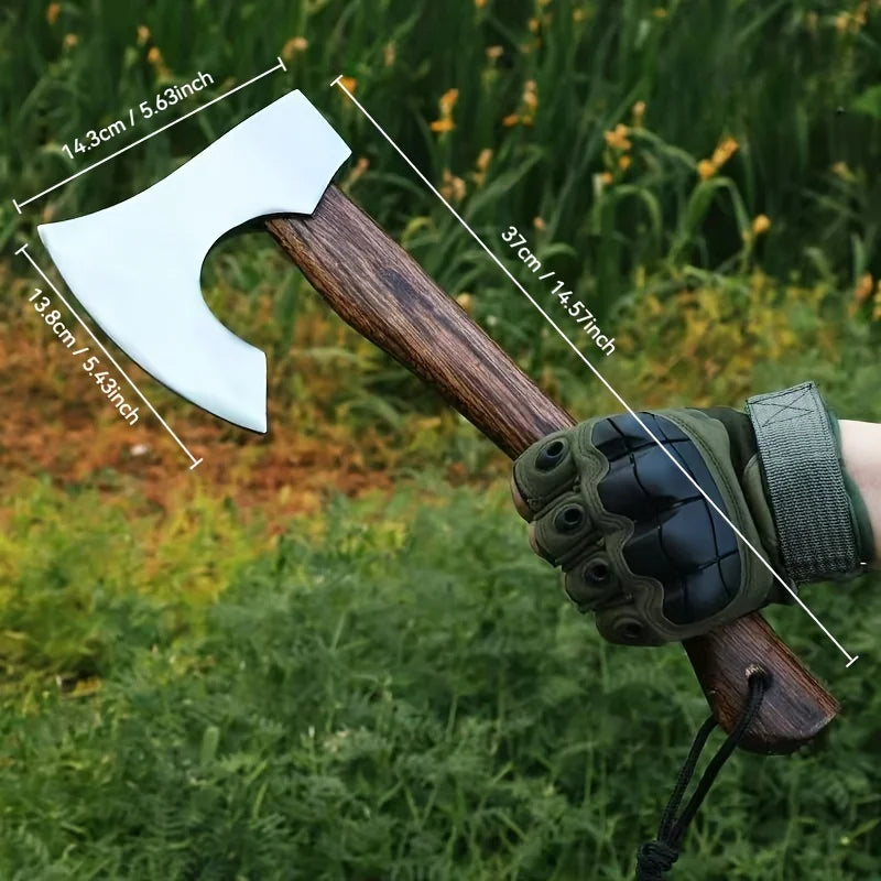 A hand-forged Viking tomahawk axe with a wooden handle and a green leather grip is shown outdoors.
