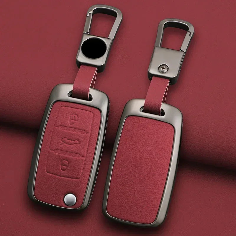 A pair of metallic car key case covers in a dusty rose color with silver clasps and rectangular key holders.