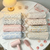 A collection of quilted cotton hair dryer storage bags in various pastel colors and patterns displayed on a white cloth.