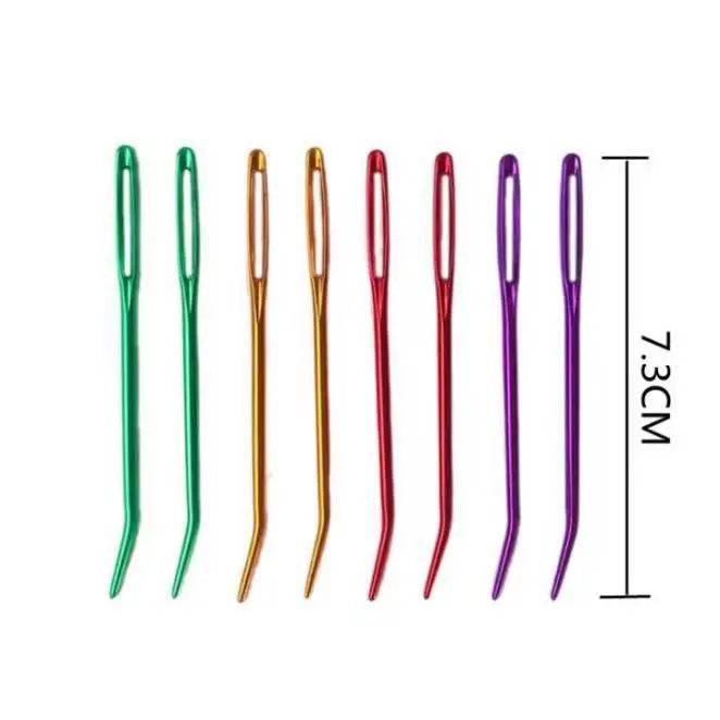 A set of ten bent tip tapestry needles in various colors, including green, copper, gold, and purple.