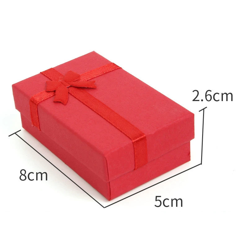 A red velvet jewelry gift box with a ribbon, showing its dimensions.