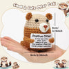 A handmade crochet positive otter doll in brown and white yarn is shown resting on a human hand.