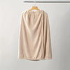 A beige, textured women's quick-dry wearable bathrobe towel hanging on a wooden hanger.