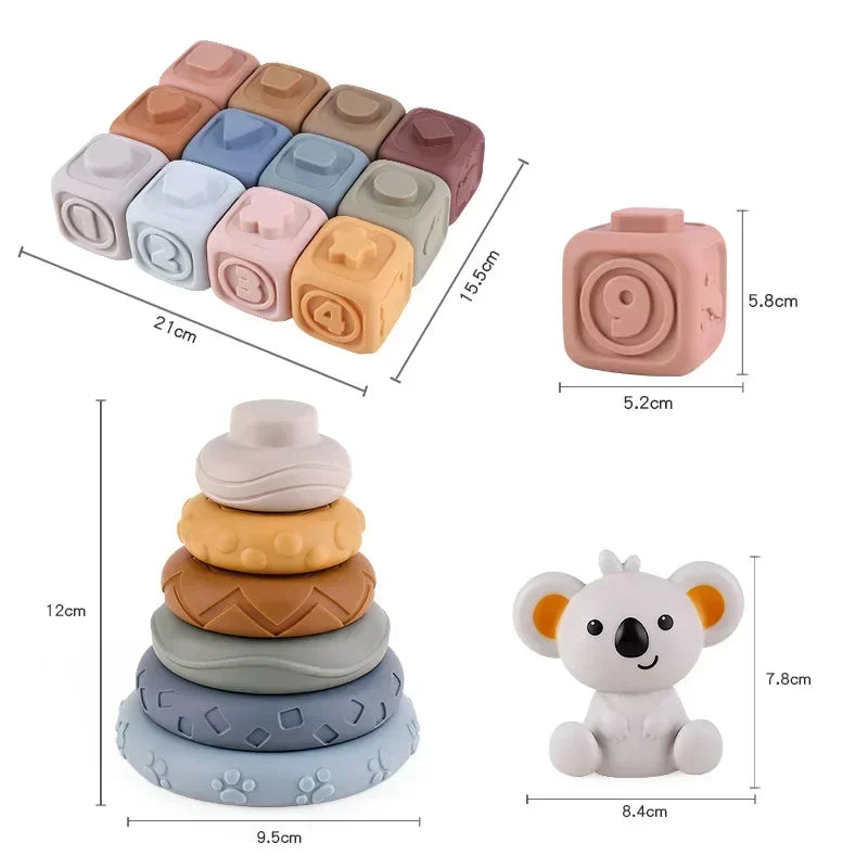 A set of soft silicone building blocks in various pastel and earthy tones, including a stack and individual pieces.