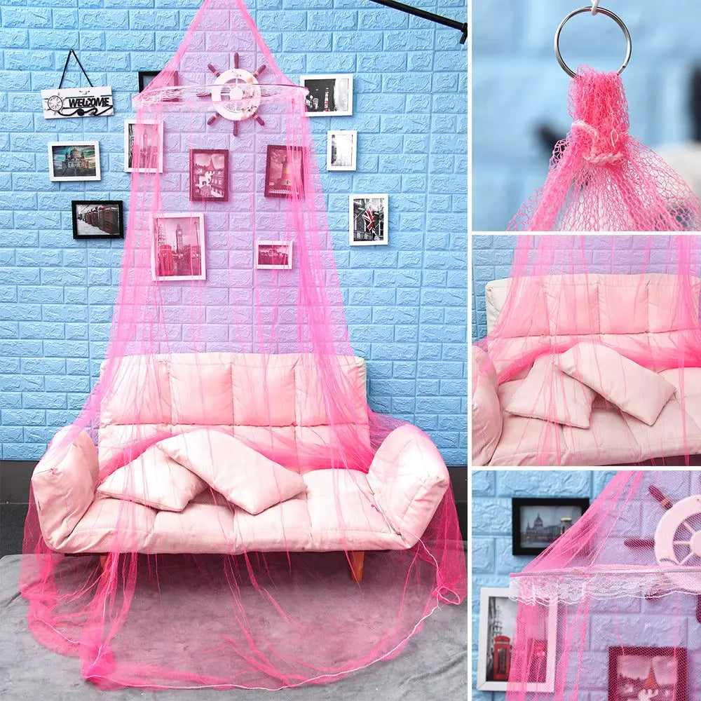 Pink lace canopy mosquito net draped over a bed with decorative framed pictures