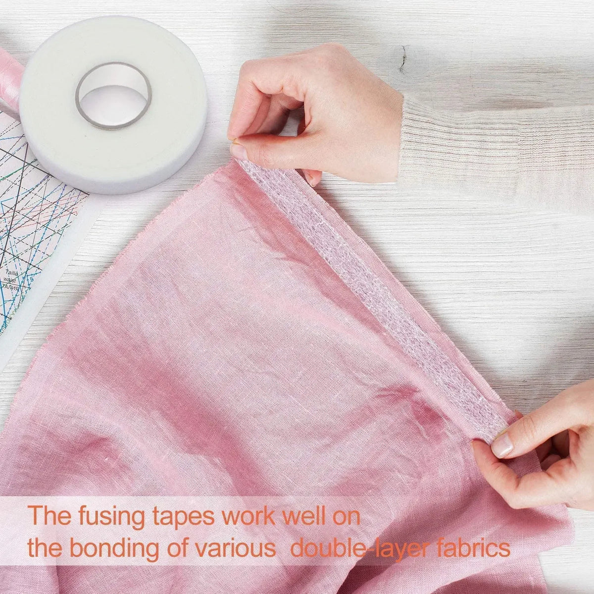 Hands are shown applying fusing tapes to bond two layers of pink fabric.