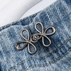 Silver adjustable clover buckle attached to denim fabric