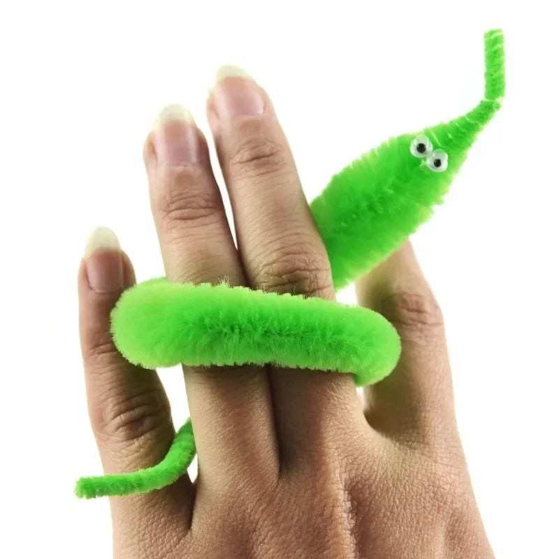 A hand holds a bright green magic slithering caterpillar trick with an elongated body.