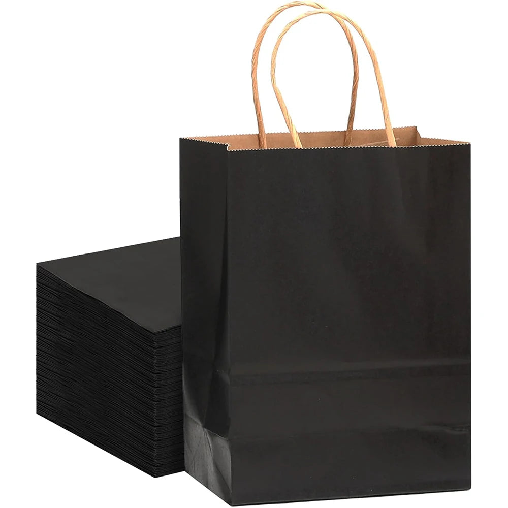 A stack of black kraft paper gift bags with natural twine handles.