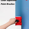 A hand is using a red color separator paint brush to separate two blue paint colors on a wall surface.