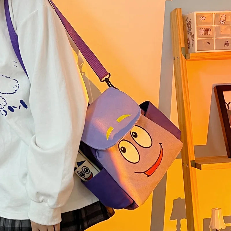Lila und gelbes Dora The Explorer Flanell-Rucksack hängt an einem Holzregal.