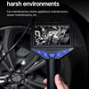A hand holds a black industrial endoscope with a screen, positioned near a car wheel.
