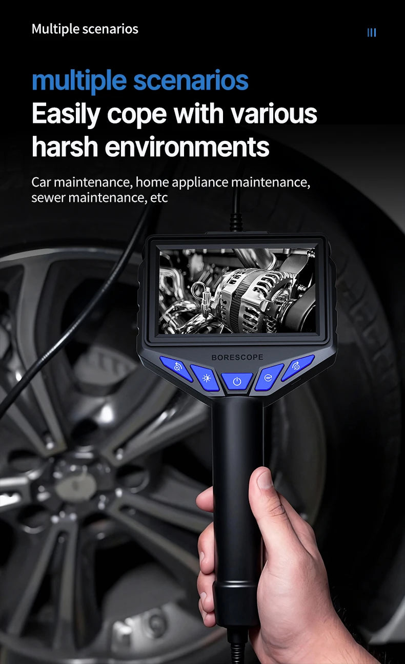A hand holds a black industrial endoscope with a screen, positioned near a car wheel.