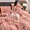 A pink faux fur bedding set featuring a duvet, pillows, and a matching throw displayed on a bed.